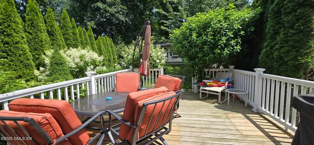 a view of a backyard with potted plants and large tree