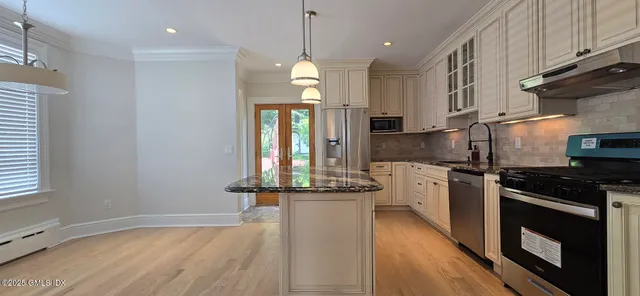 a kitchen with stainless steel appliances granite countertop a stove and cabinets