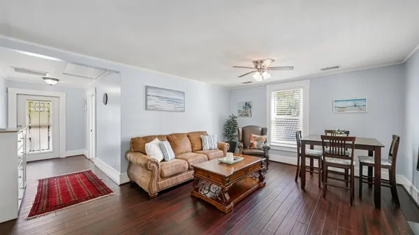 a living room with furniture and a wooden floor