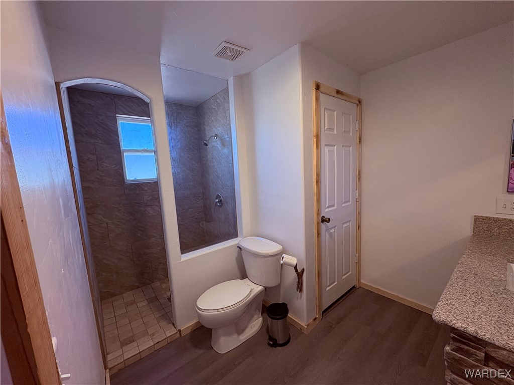 1757 Glenbar Road Golden Valley, AZ 86413 - Photo 12 of 33 Bathroom with toilet, wood finished floors, baseboards, and walk in shower