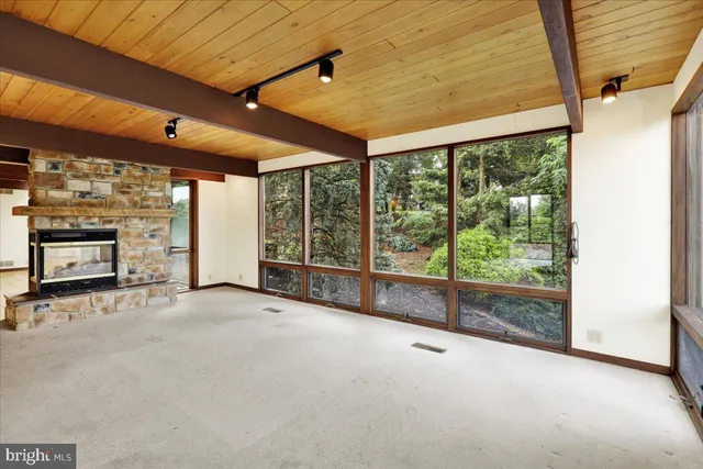 a view of an empty room with wooden floor and door