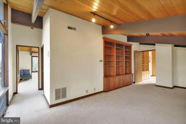 a spacious bedroom with a large bed and a chandelier