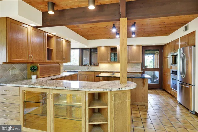 a kitchen with stainless steel appliances granite countertop a sink a stove and chairs