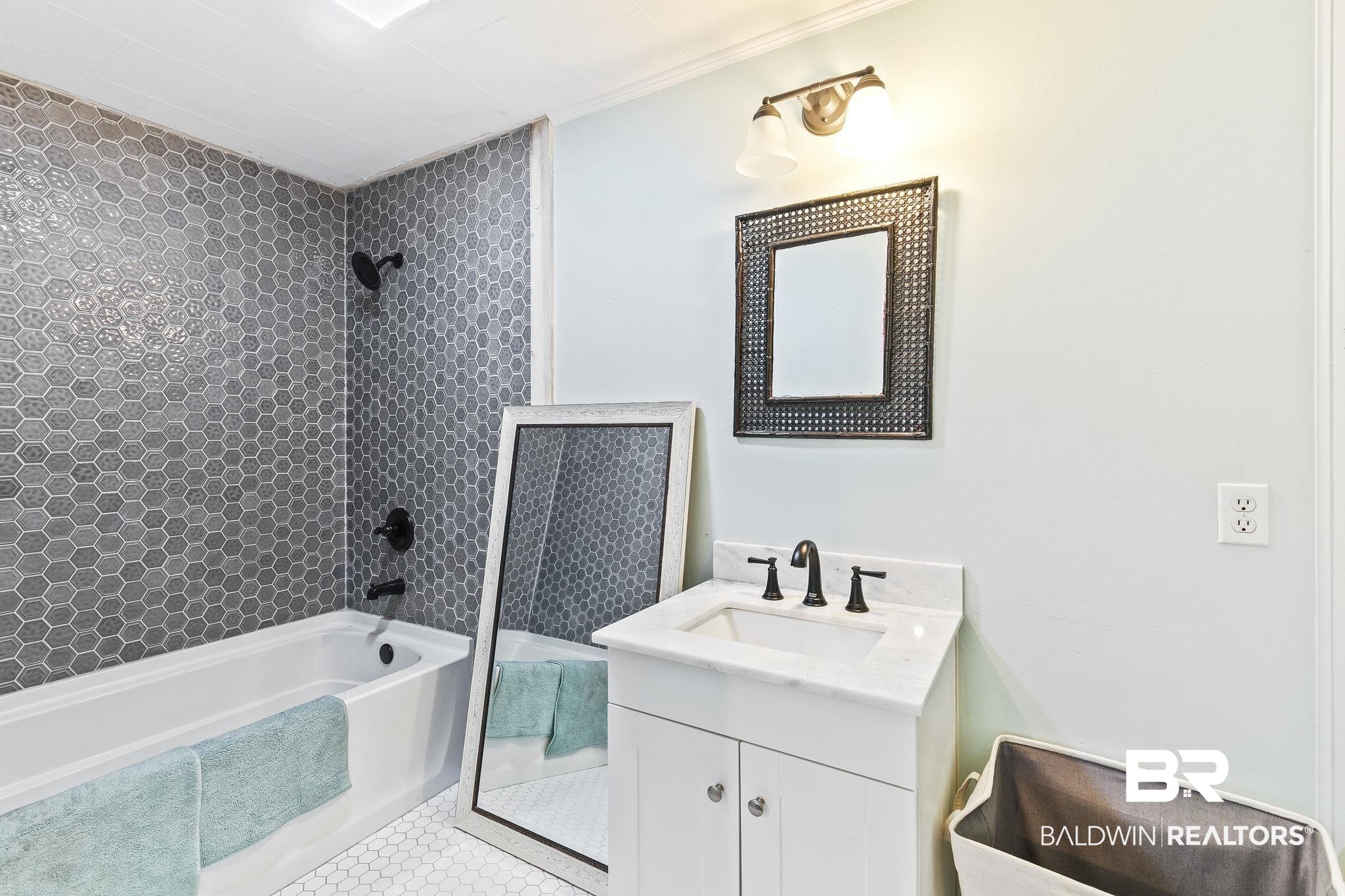 316 West Orchid Avenue Foley, AL 36535 - Photo 20 of 38 Full bathroom featuring vanity, bathing tub / shower combination, and light tile patterned floors