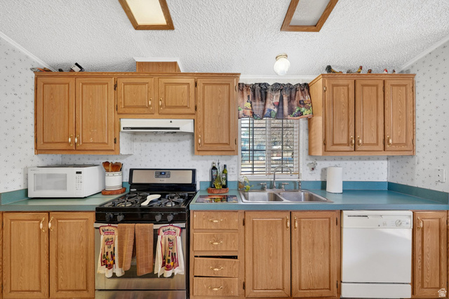 269 Mindella Way, Unit A Layton, UT 84041 - Photo 9 of 37 Kitchen with white appliances, a textured ceiling, crown molding, wallpapered walls, and wood finish cabinetry