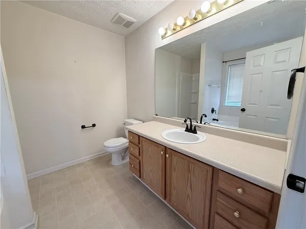 a bathroom with a sink a toilet and a mirror