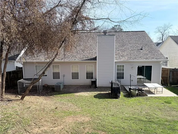 a view of a house with backyard and furniture