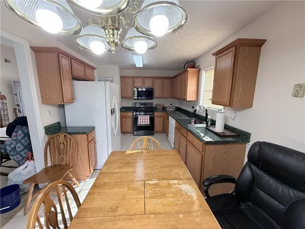 a kitchen with stainless steel appliances granite countertop a stove a sink dishwasher and a refrigerator