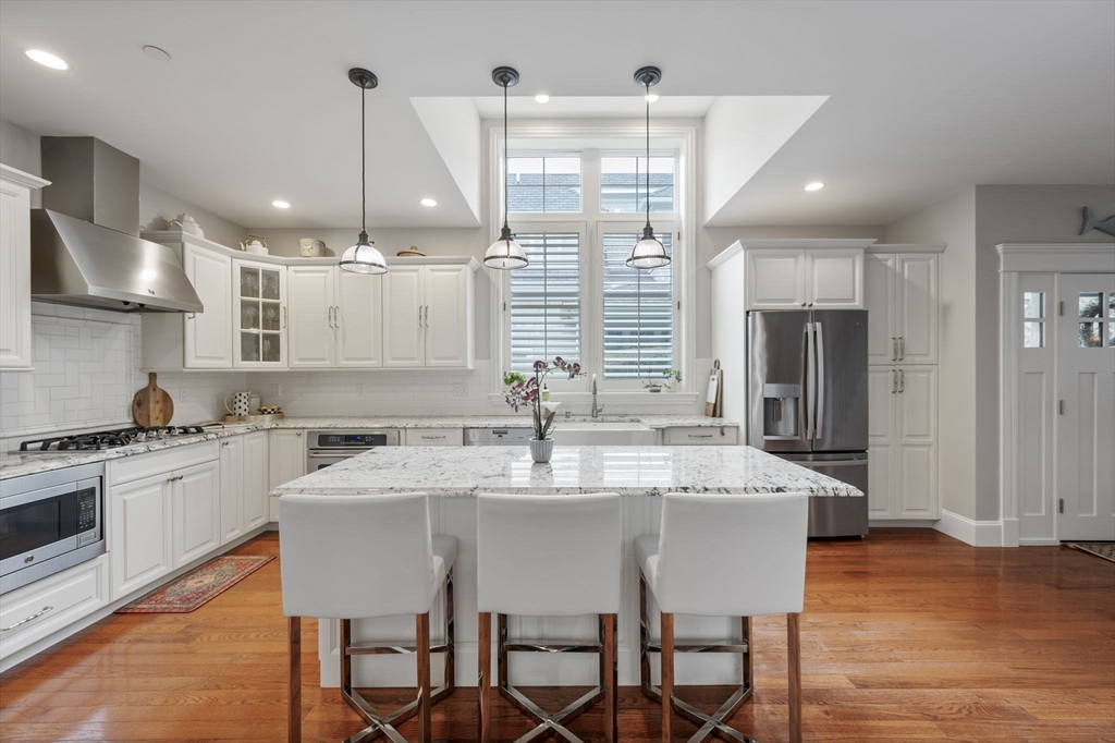 10 Backriver Road, Unit 10 Hingham, MA 02043 - Photo 4 of 31 a kitchen with stainless steel appliances granite countertop a kitchen island a stove a table and chairs