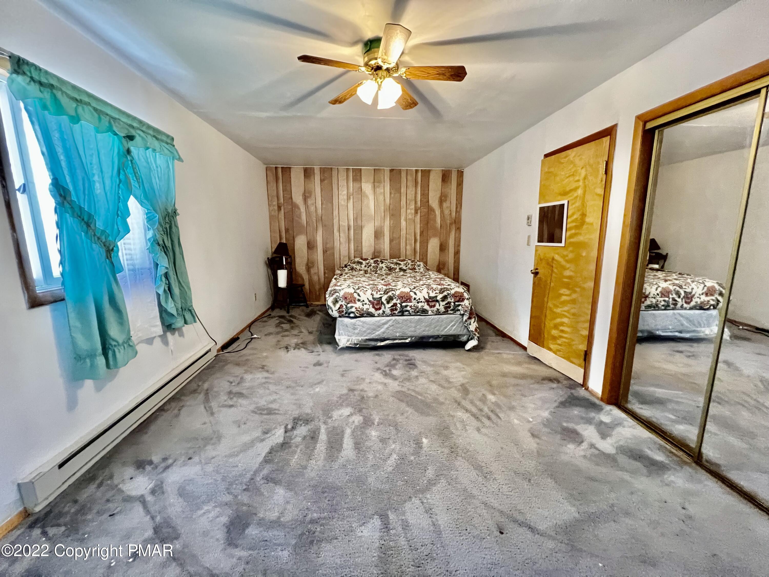152 Caribou Road Dingmans Ferry, PA 18328 - Photo 12 of 15 a spacious bedroom with a bed and a large window