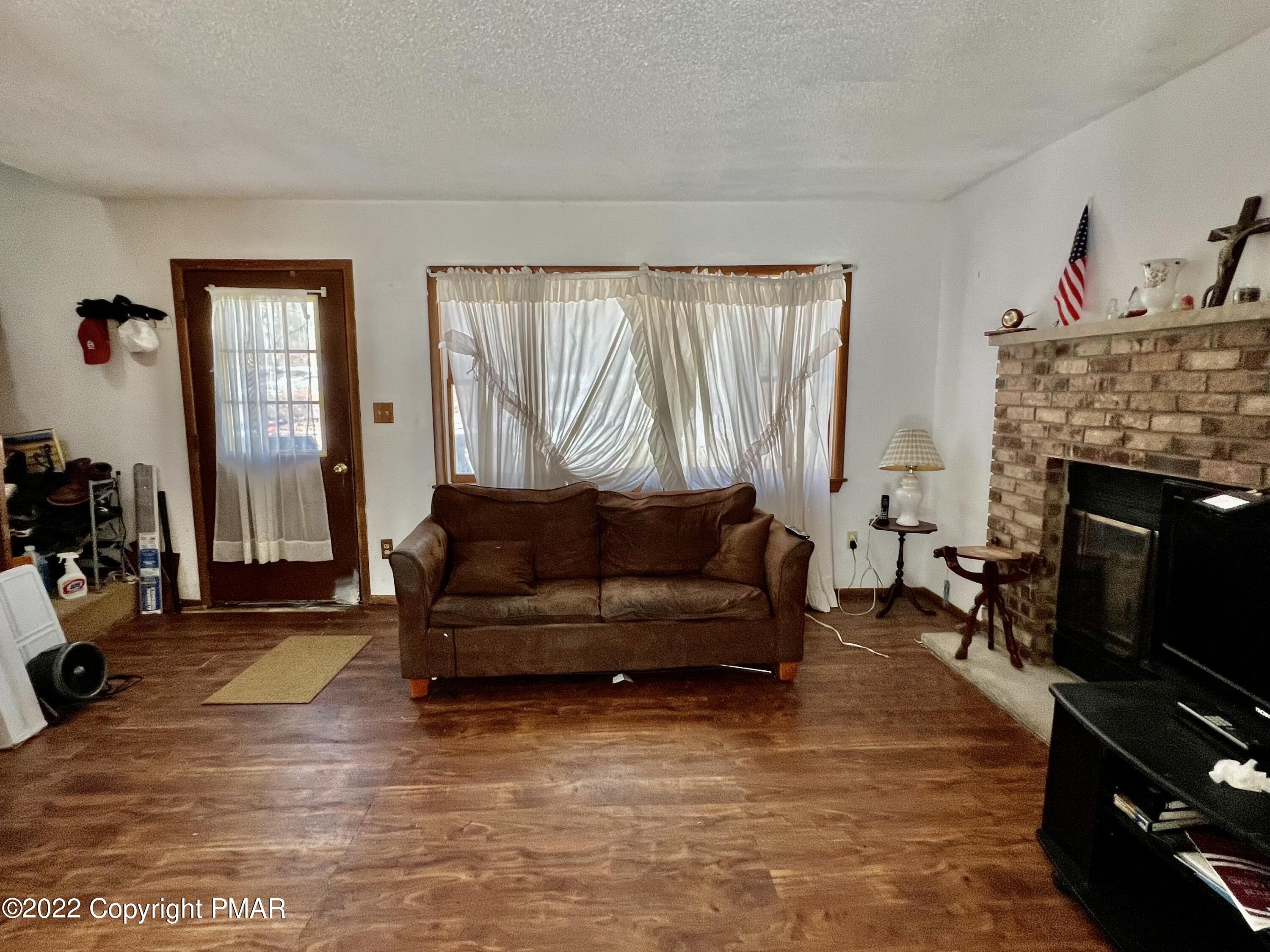 152 Caribou Road Dingmans Ferry, PA 18328 - Photo 3 of 15 a living room with furniture and a fireplace