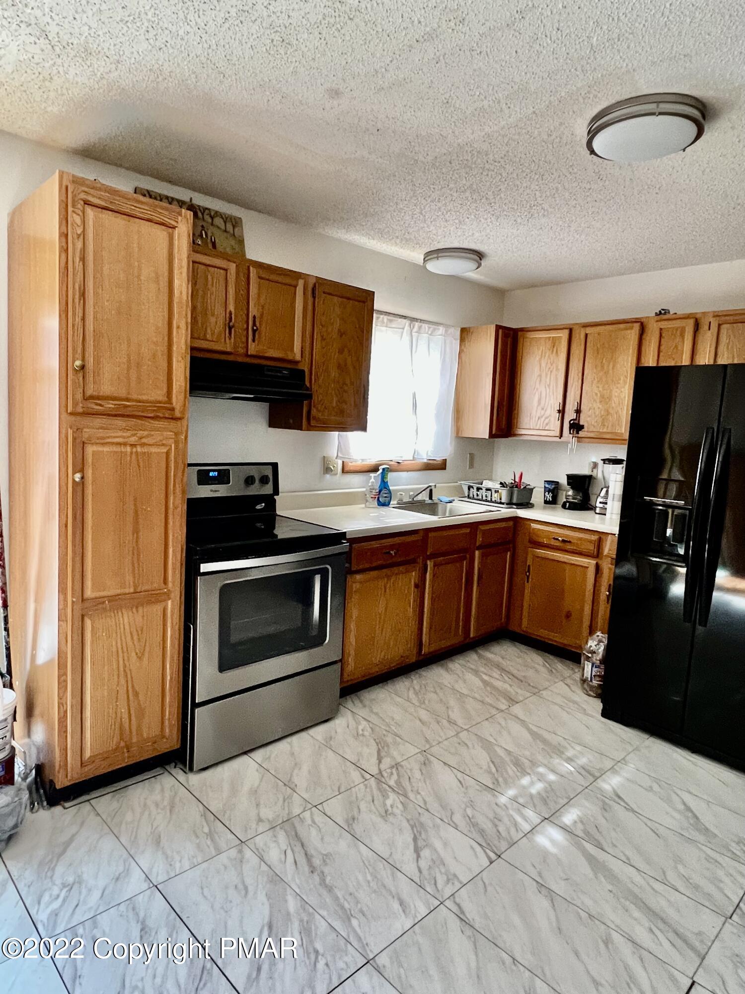 152 Caribou Road Dingmans Ferry, PA 18328 - Photo 7 of 15 a kitchen with granite countertop a sink stainless steel appliances and cabinets