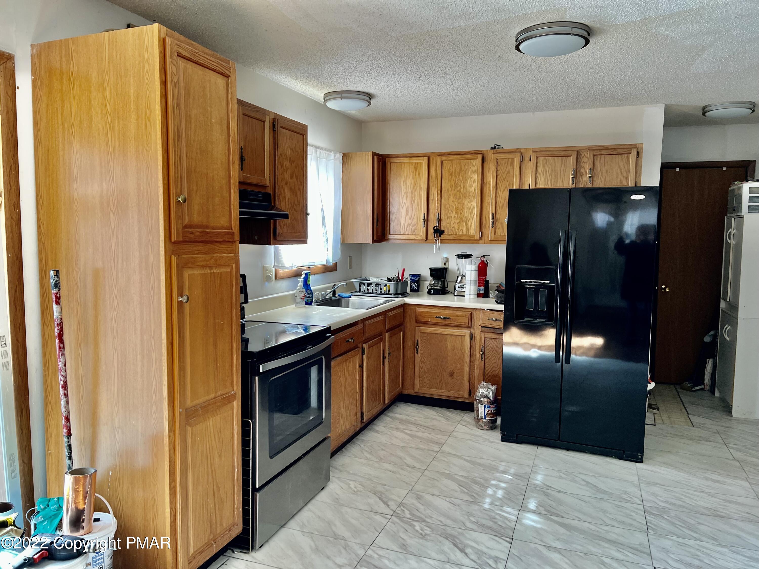 152 Caribou Road Dingmans Ferry, PA 18328 - Photo 8 of 15 a kitchen with stainless steel appliances granite countertop a refrigerator and a stove top oven