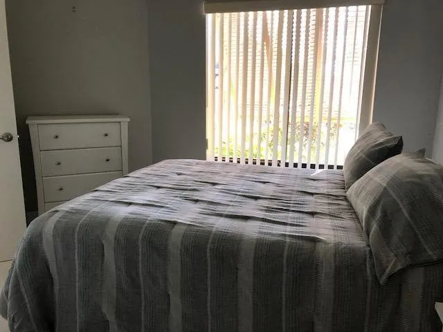 a bedroom with a bed and a window