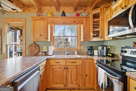 a kitchen with granite countertop a stove a sink and dishwasher next to a window