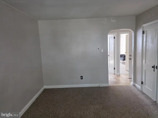 a view of a hallway with wooden floor and a bathroom