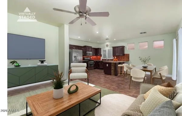 a living room with furniture kitchen view and a wooden floor
