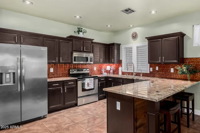 a kitchen with granite countertop a stove refrigerator and microwave