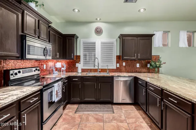a kitchen with stainless steel appliances granite countertop a sink and a stove