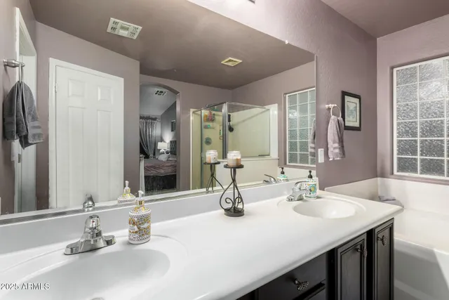 a bathroom with double vanity sinks and a mirror