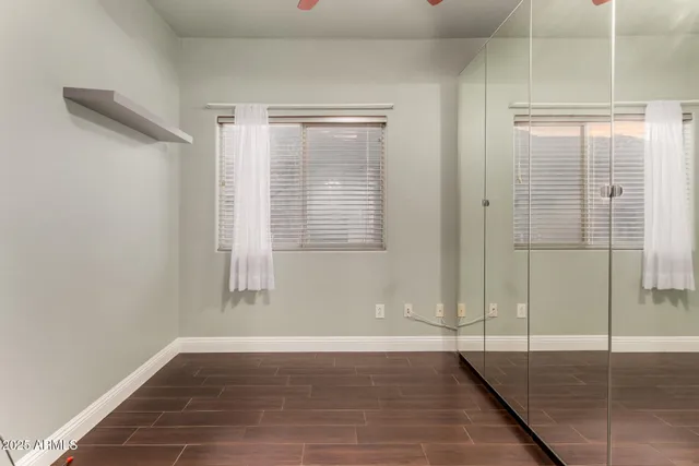a view of an empty room with wooden floor and a bathroom