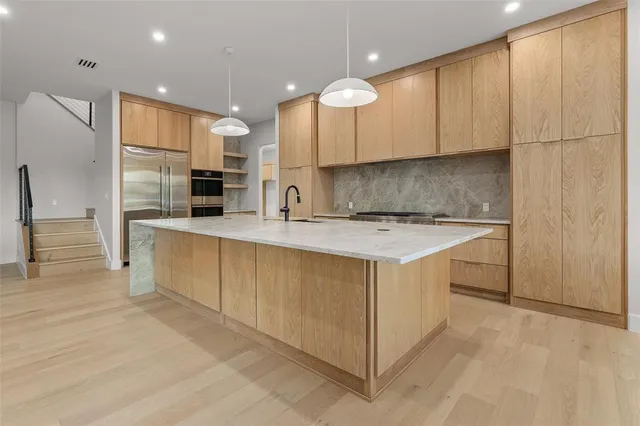 a kitchen that has a lot of cabinets and wooden floor