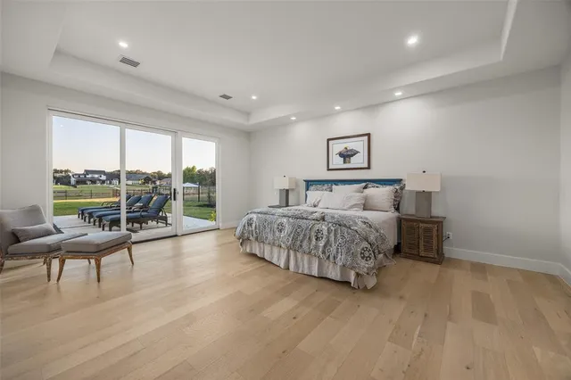a bedroom with a large bed and a wooden floor