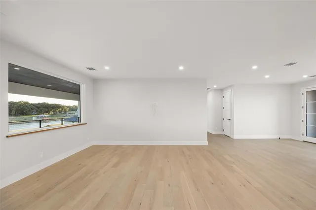 an empty room with wooden floor and a window