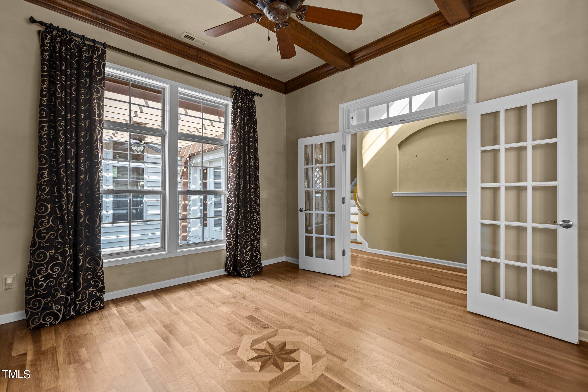6112 Blakeman Lane Raleigh, NC 27617 - Photo 7 of 56 a view of an empty room with a window and wooden floor