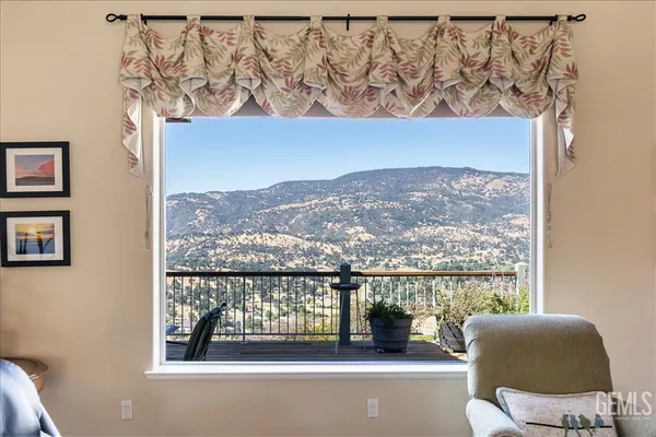 a living room with furniture two window and a flat screen tv