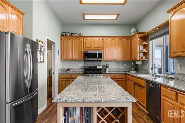 a large kitchen with granite countertop a large window and stainless steel appliances