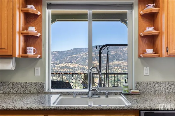 a kitchen with stainless steel appliances granite countertop a refrigerator a stove and a wooden floors