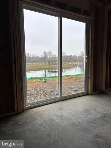 a view of an empty room with wooden floor and floor to ceiling window