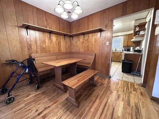 a room with wooden floor table and chairs
