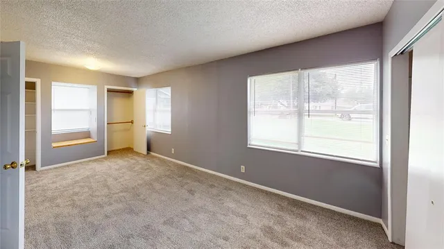 an empty room with windows and closet