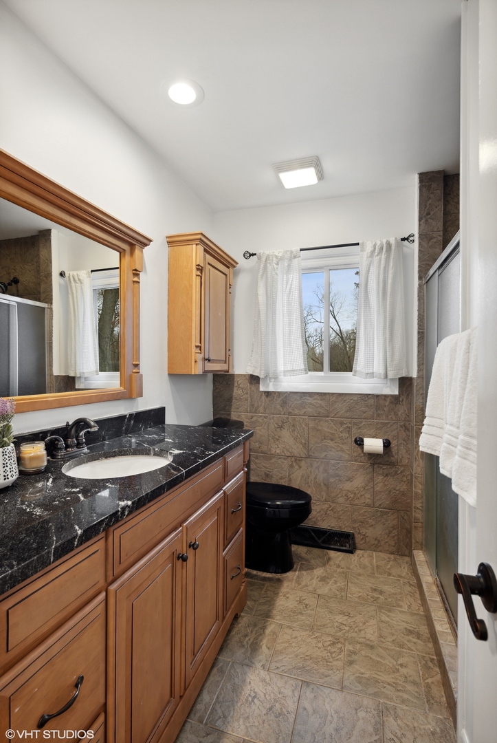 607 Pine Street Batavia, IL 60510 - Photo 16 of 39 a spacious bathroom with a granite countertop sink a toilet and mirror