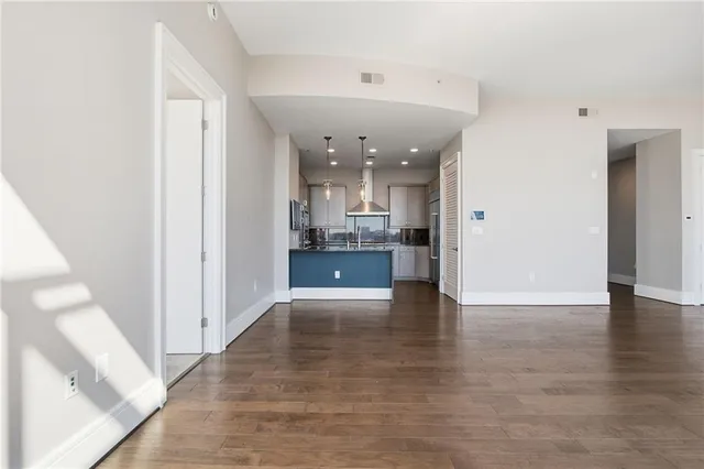a kitchen with kitchen island granite countertop a dining table chairs and white cabinets