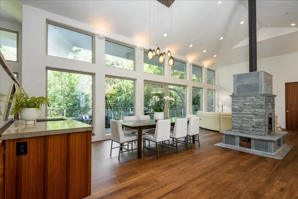 a dining room with furniture large windows and wooden floor