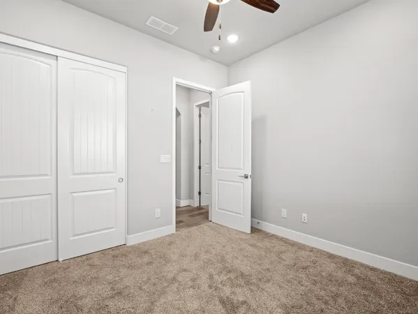 an empty room with a ceiling fan and shower