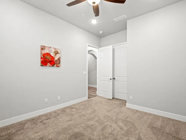 an empty room with fan and entryway