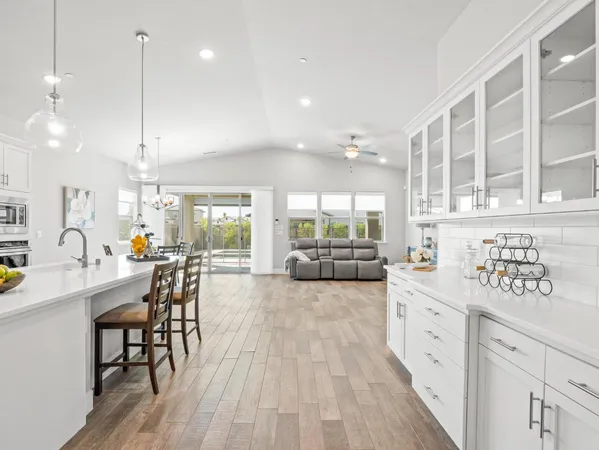 a kitchen with stainless steel appliances a dining table chairs and stove top oven