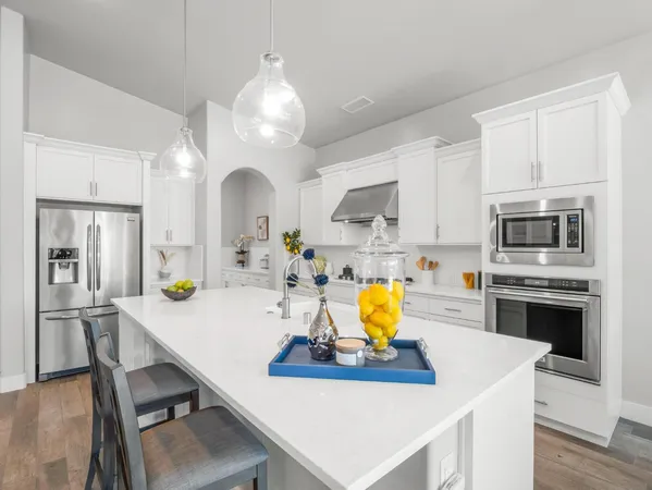 a large white kitchen with stainless steel appliances
