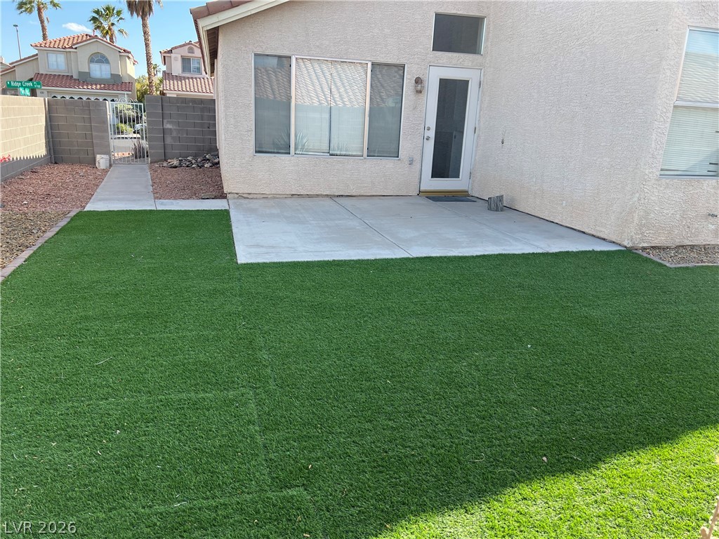 9708 Ridge Creek Place Las Vegas, NV 89134 - Photo 30 of 34 A low-maintenance yard offers both a paved patio and lush artificial turf for outdoor enjoyment.