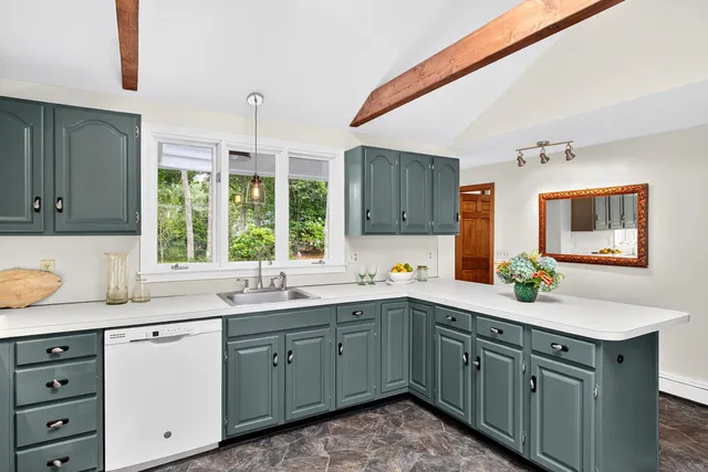a kitchen with a sink window and cabinets