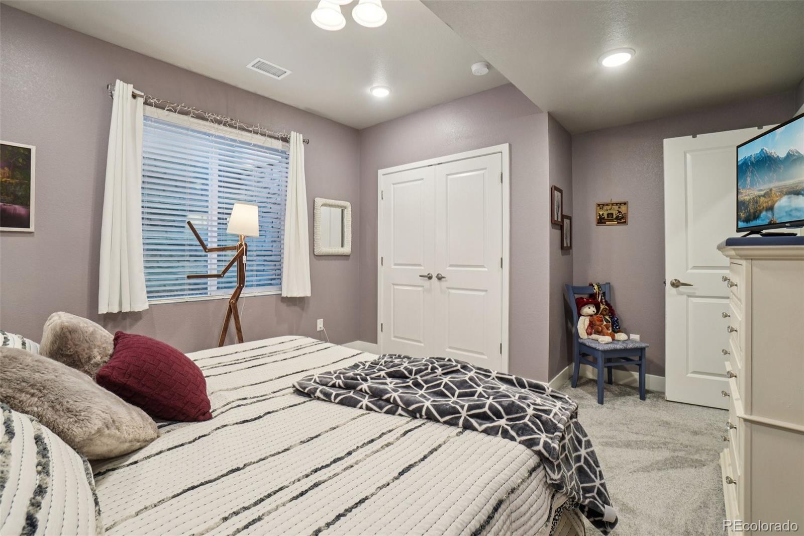 12541 Lake View Street Firestone, CO 80504 - Photo 26 of 50 a bedroom with a bed and a flat tv screen