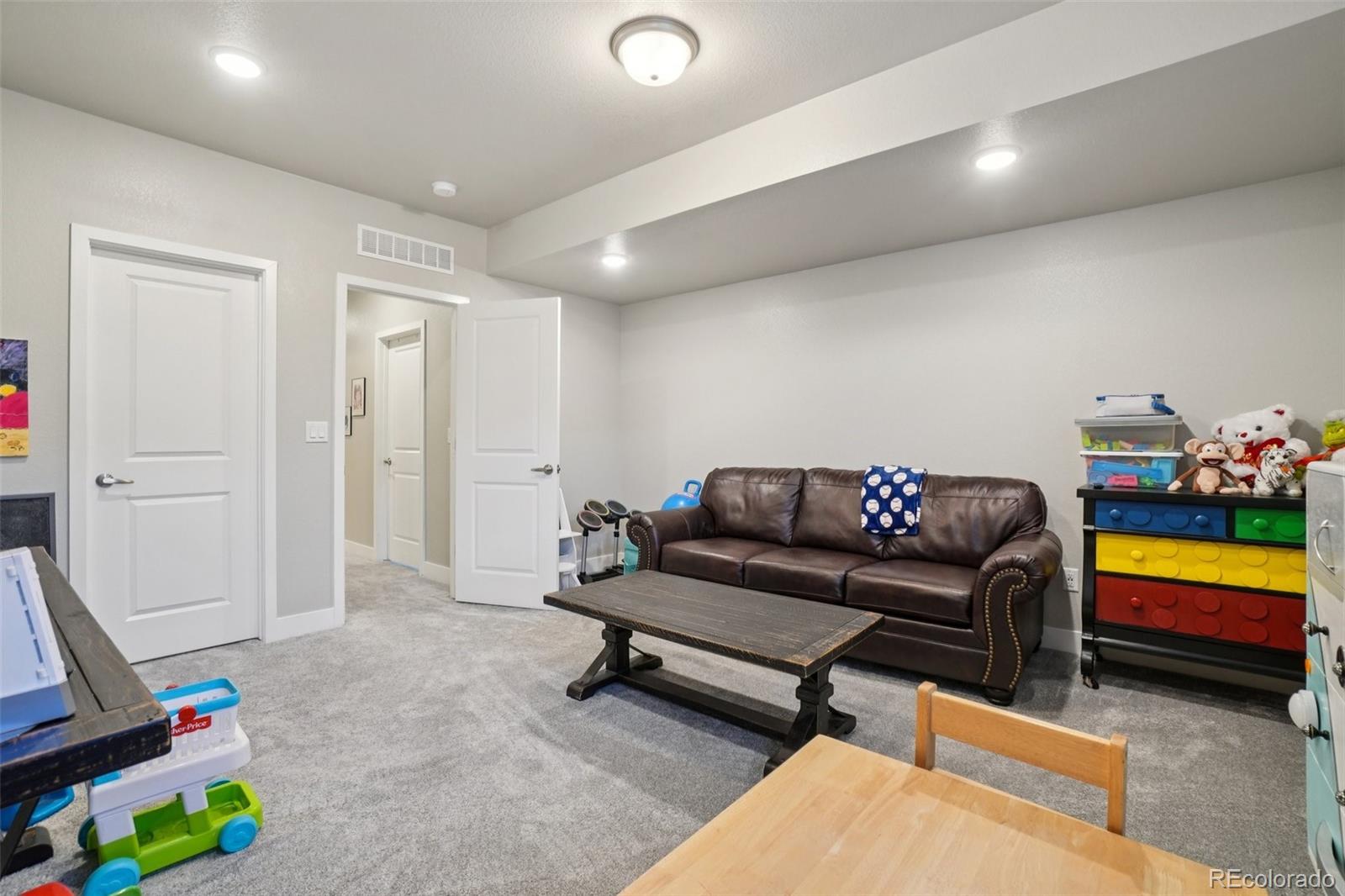 12541 Lake View Street Firestone, CO 80504 - Photo 28 of 50 a living room with furniture and a baby crib with wooden floor