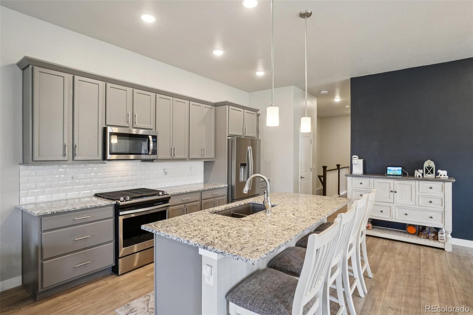 12541 Lake View Street Firestone, CO 80504 - Photo 5 of 50 a kitchen with granite countertop a sink stove and refrigerator