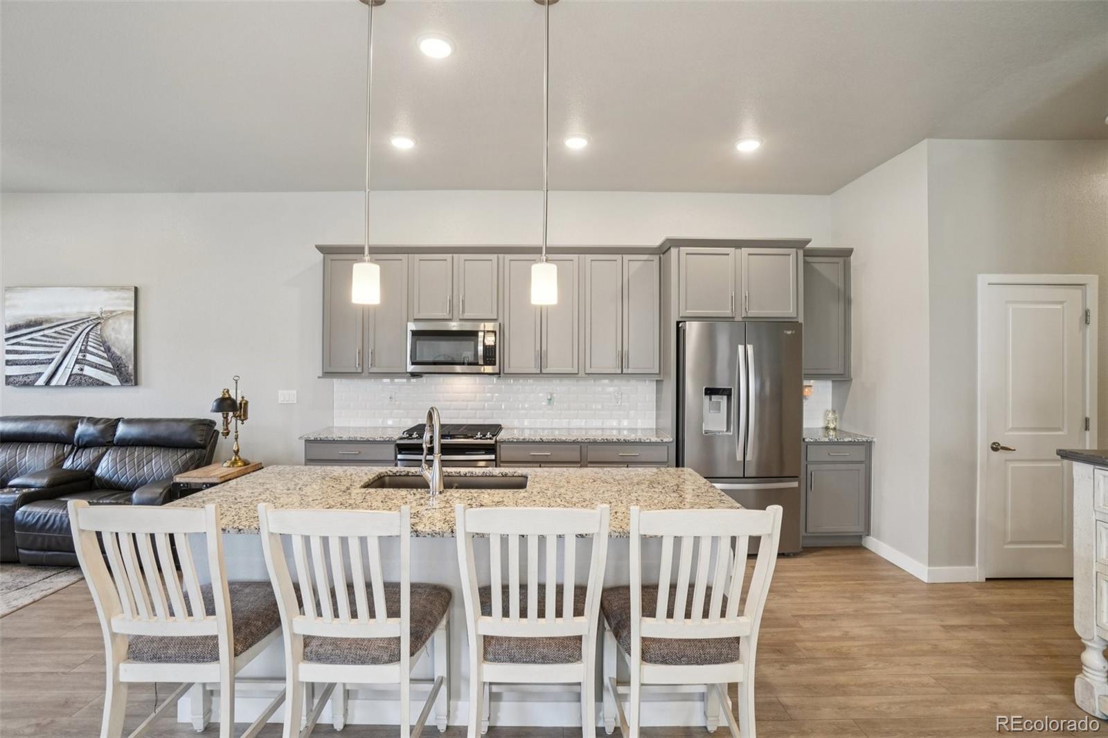 12541 Lake View Street Firestone, CO 80504 - Photo 6 of 50 a kitchen with stainless steel appliances a kitchen island hardwood floor and a sink