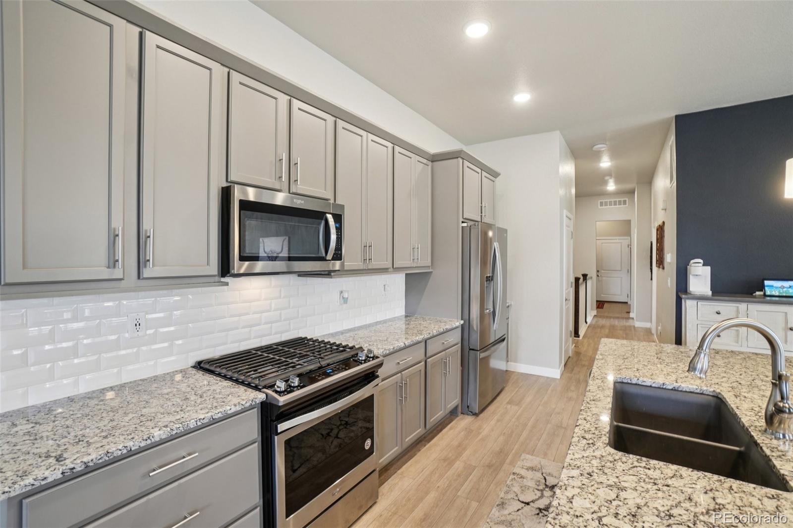 12541 Lake View Street Firestone, CO 80504 - Photo 8 of 50 a kitchen with stainless steel appliances granite countertop a stove a sink and a microwave