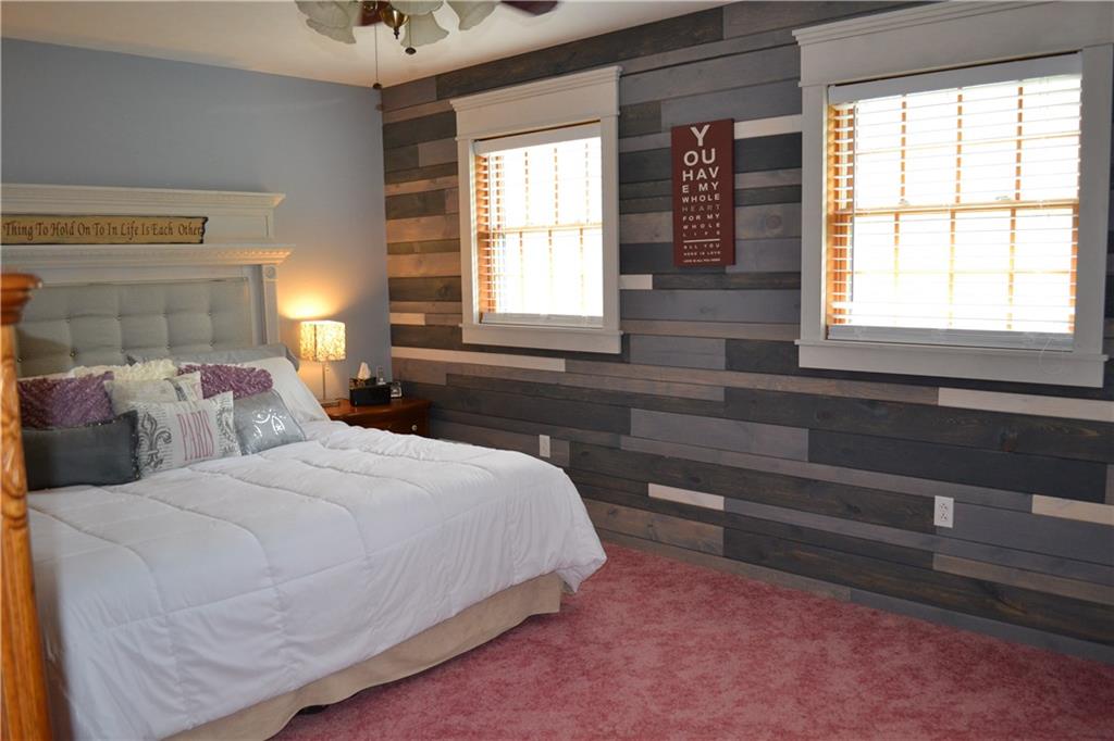 150 Adams Road Kittanning, PA 16201 - Photo 10 of 25 Large master suite with plank wood accent wall featuring farmhouse window trim.